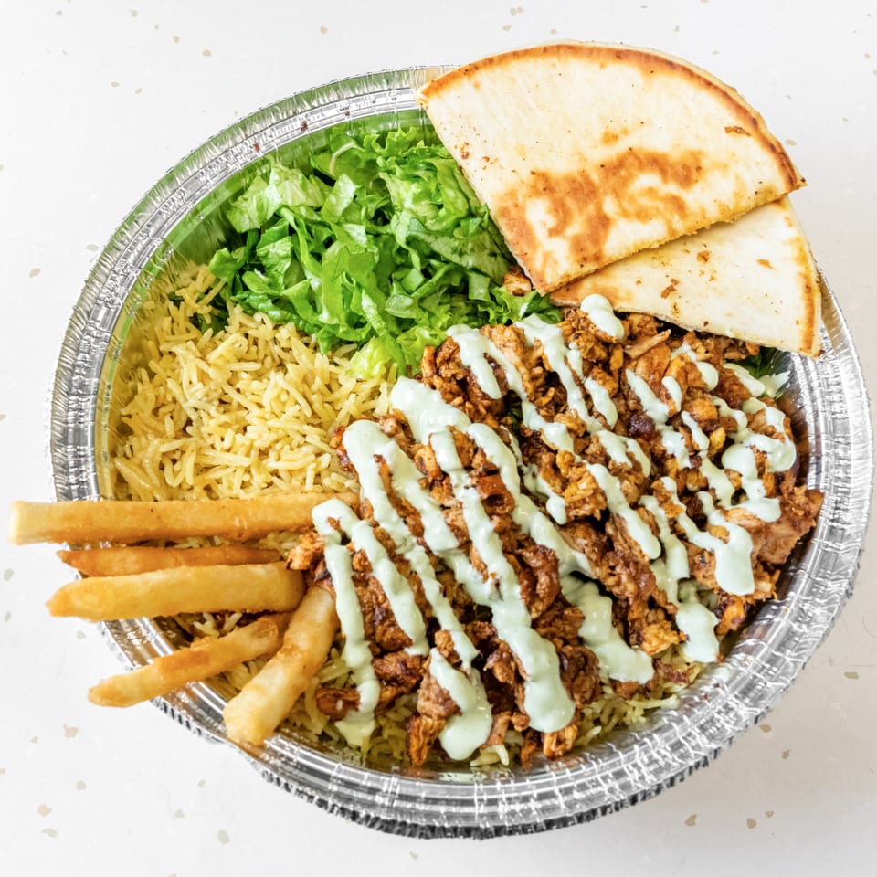 Fried Shack's fried chicken platter with rice, lettuce, fries, pita bread, and white sauce.