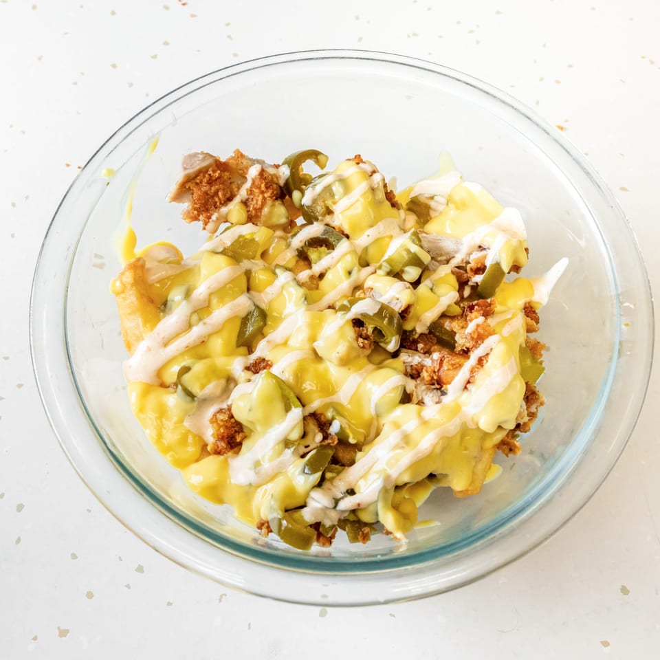 Fried Shack's fried chicken, jalapeños, and cheese sauce in a glass bowl.